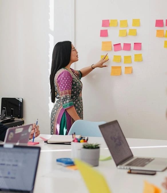 Student reviewing creative concepts on a sticky-note wall