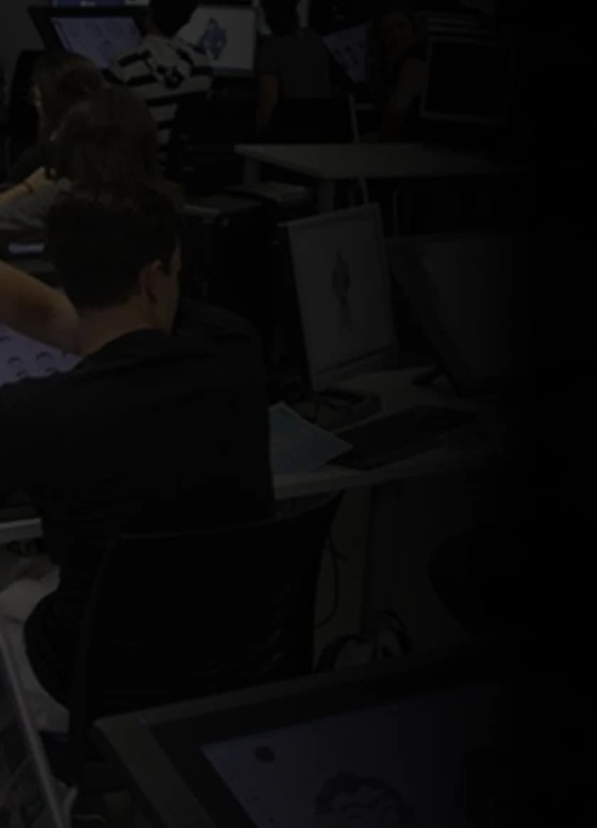 Students working on tablets and monitors in a production lab