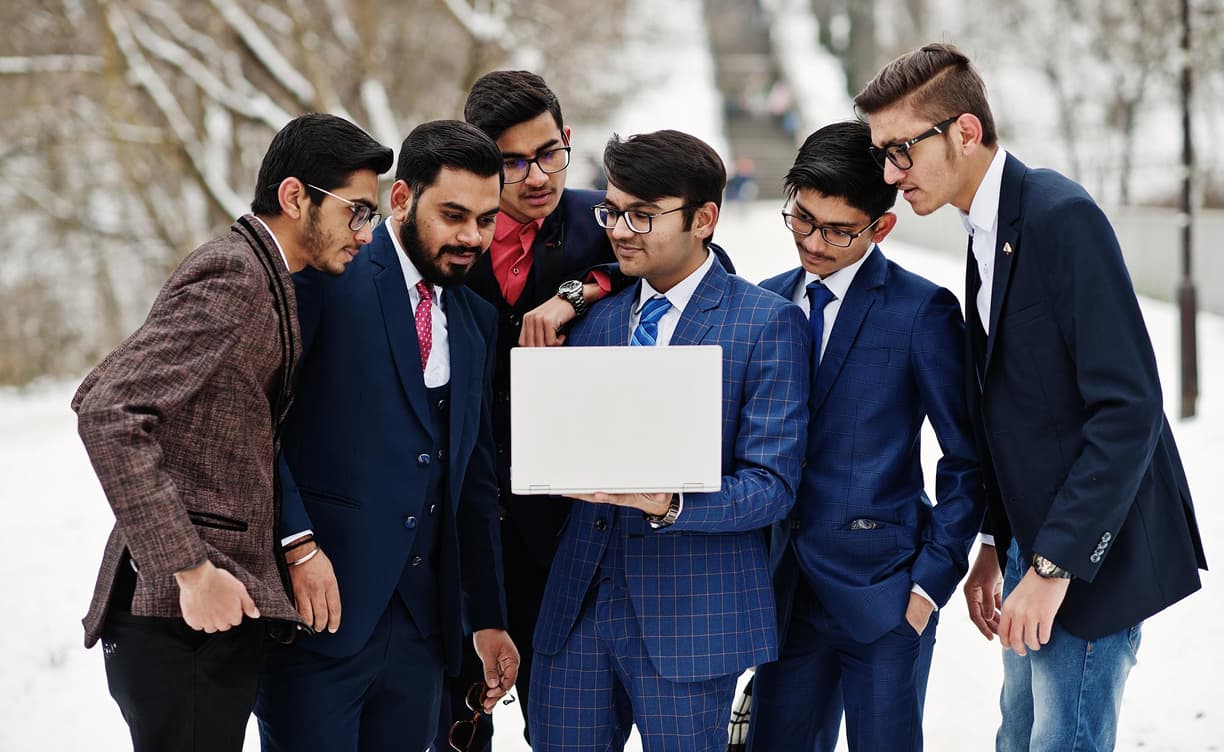Professionals collaborating around a laptop outdoors
